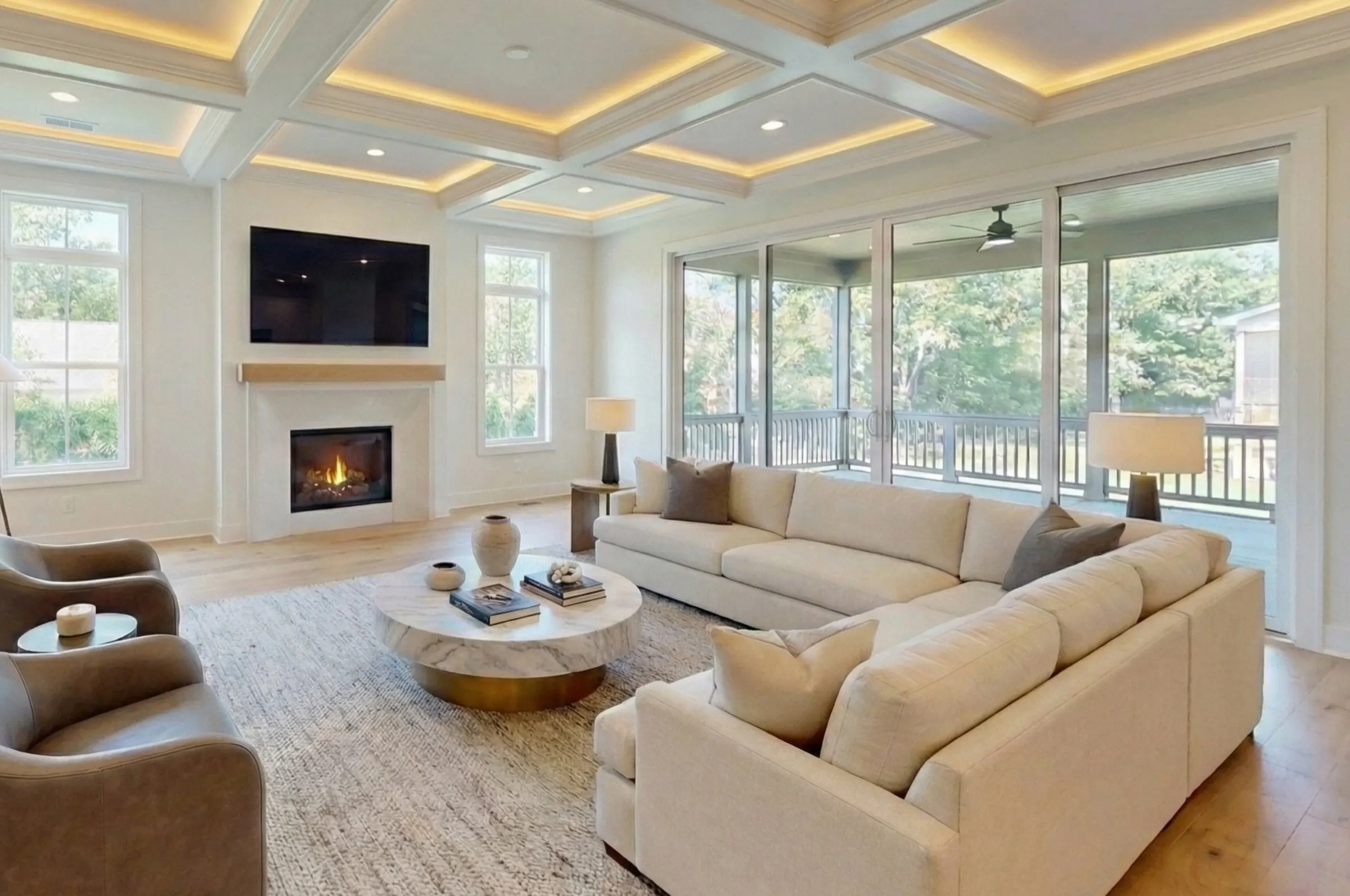 Family room with coffered ceiling, fireplace, and sliding glass doors to a screened porch at a Colonial build in Kensington